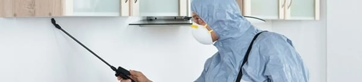 Termite treatment technician applying indoor pest control spray in Fresno, CA
